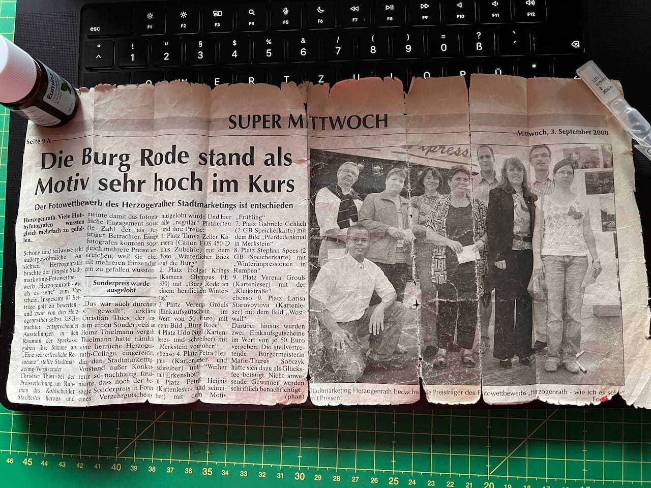 Ein Zeitungsausschnitt aus der „Super Sonntag“ vom 3. September 2008. Im Artikel wird über einen Fotowettbewerb des Herzogenrather Stadtmarketings berichtet. Thema des Wettbewerbs: „Herzogenrath - wie ich es sehe“. Neben dem Artikel ist ein Gruppenfoto der Gewinner*innen. 