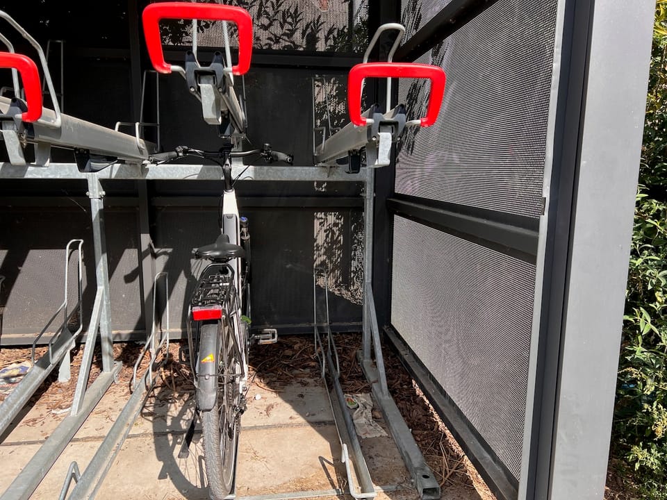 ein Ausschnitt einer Fahrradbox aus Metall, in der ein Fahrrad steht